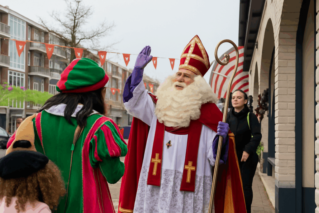 Sinterklaas en Piet vieren feest op straat.